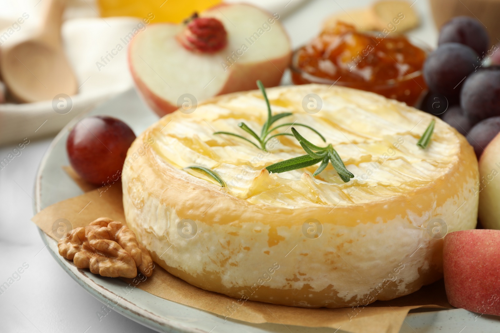 Photo of Tasty baked brie cheese served on table, closeup