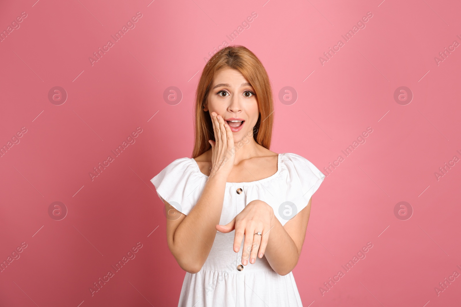 Photo of Excited woman with engagement ring on pink background