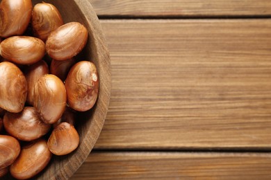 Photo of Plate of jackfruit seeds on wooden table, top view. Space for text