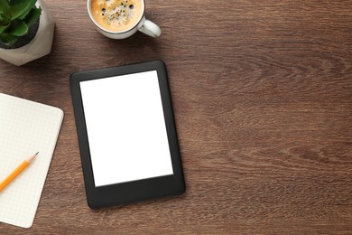 Photo of Modern ebook reader, plant, coffee and notebook on wooden table, flat lay. Space for text