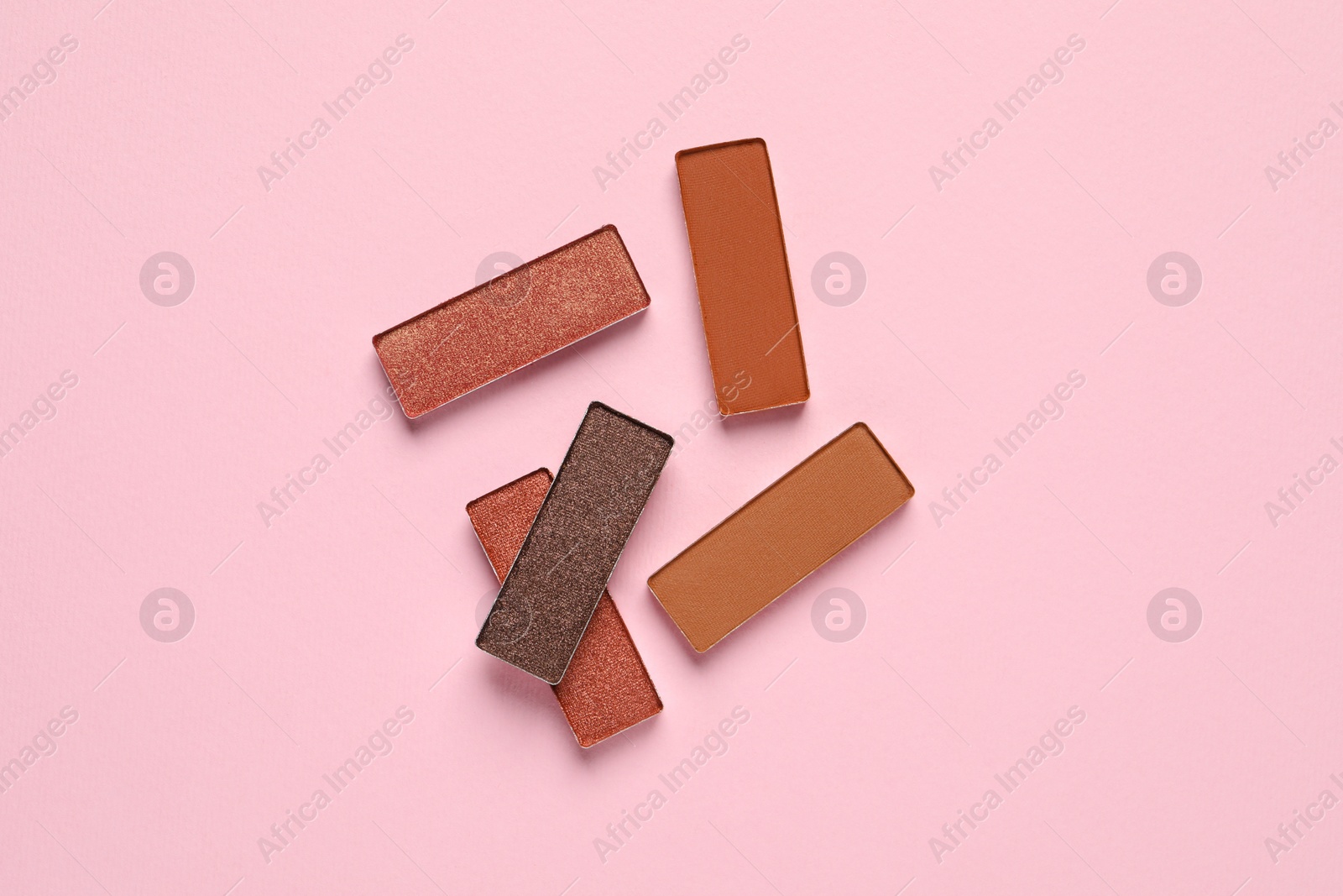 Photo of Different beautiful eye shadows on pink background, flat lay