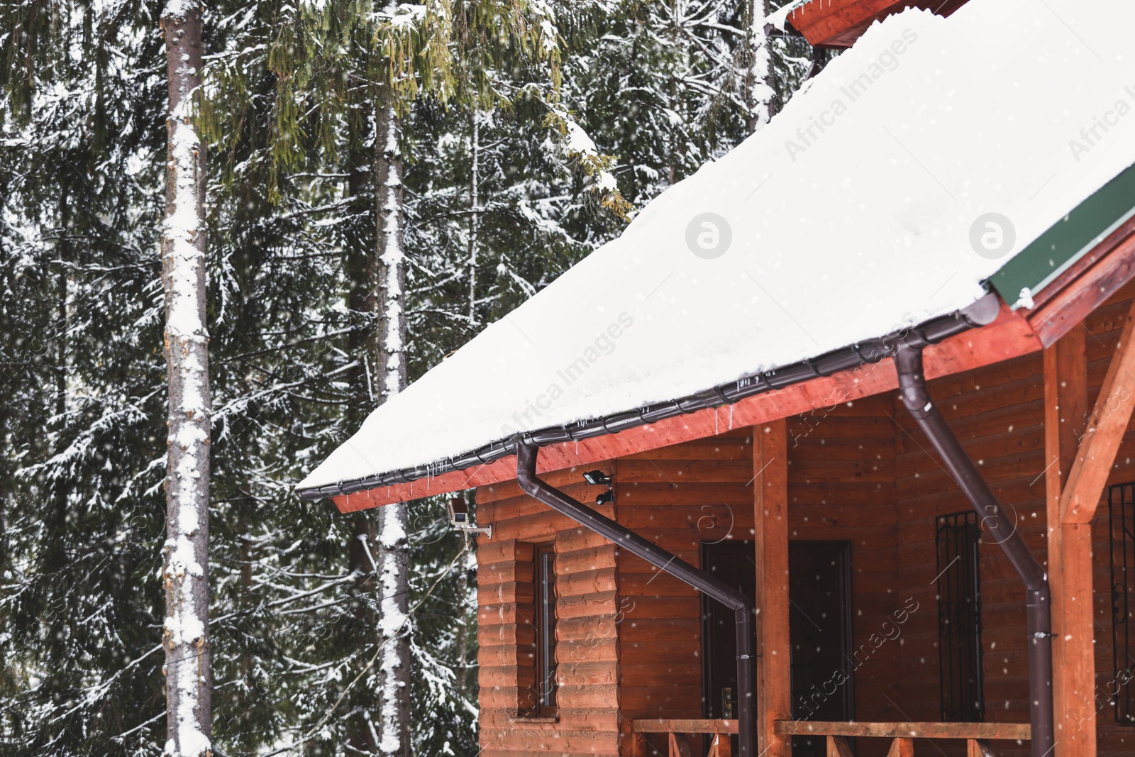 Photo of Wooden cottage with snowy roof. Winter vacation