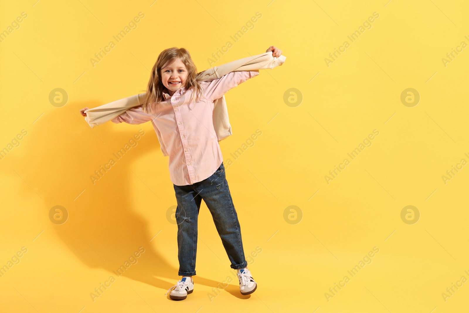 Photo of Fashion concept. Stylish girl posing on yellow background. Space for text