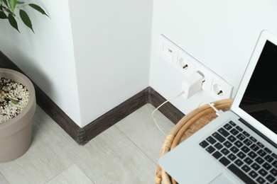 Photo of Electric power outlet sockets with charger on white wall