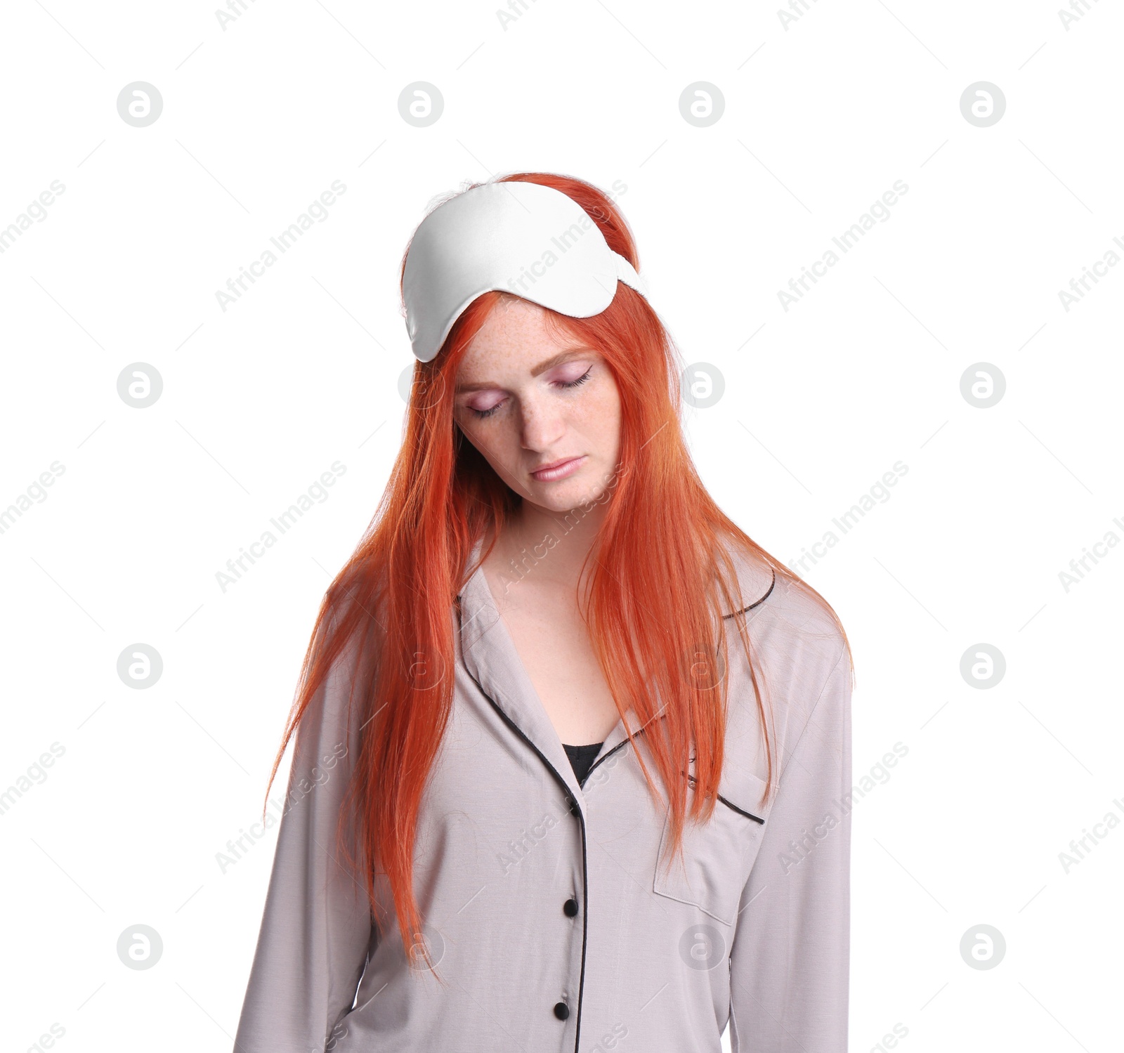 Photo of Young woman wearing pajamas and mask in sleepwalking state on white background