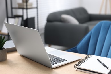 Photo of Home workspace. Laptop and stationery on wooden desk indoors