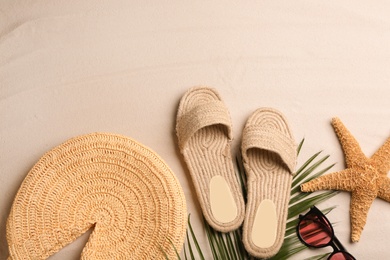 Different beach accessories on sand, flat lay. Space for text