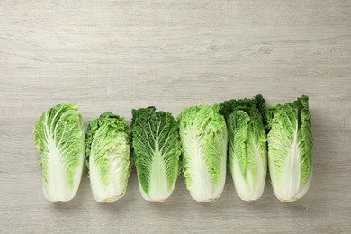 Fresh ripe Chinese cabbages on white wooden table, flat lay. Space for text