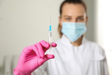 Doctor with syringe in hospital, focus on hand. Vaccination day