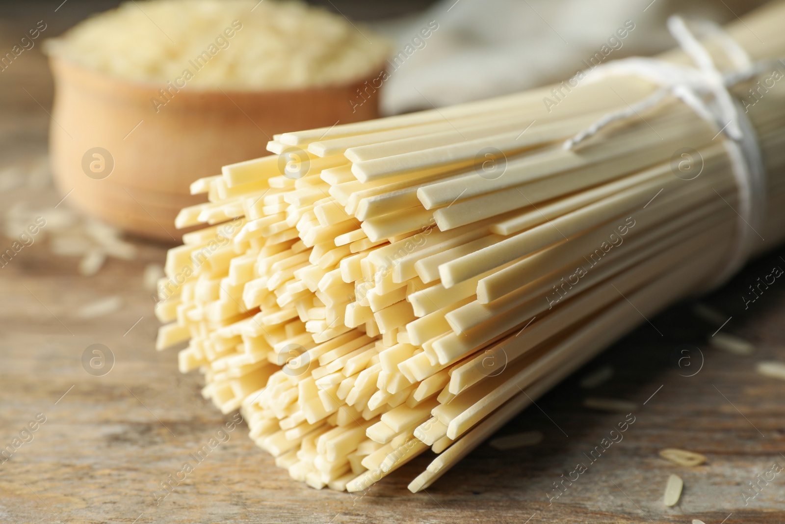 Photo of Raw rice noodles on wooden table, closeup