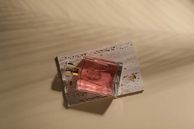 Luxury women's perfume in bottle on beige background, top view