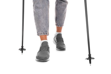 Woman wearing stylish shoes with trekking poles on white background, closeup