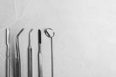 Photo of Professional dentist tools on grey background, flat lay. Space for text