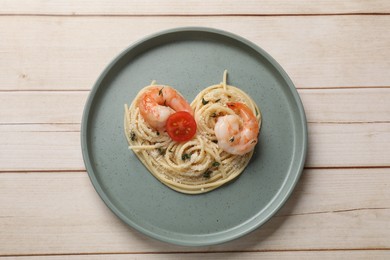 Photo of Heart made of tasty spaghetti, tomato, shrimps and cheese on light wooden table, top view