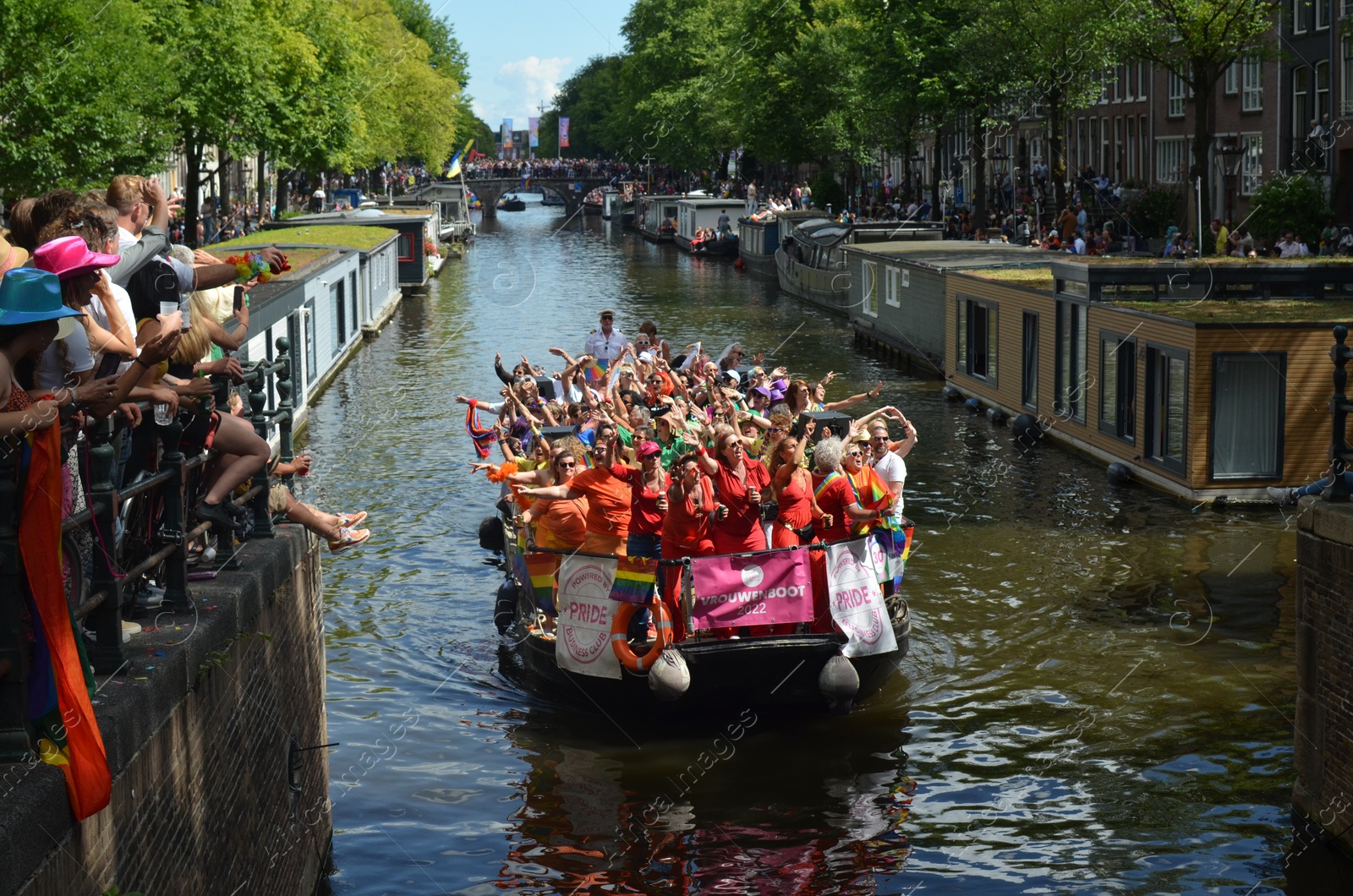 Photo of AMSTERDAM, NETHERLANDS - AUGUST 06, 2022: Many people in boat at LGBT pride parade on river