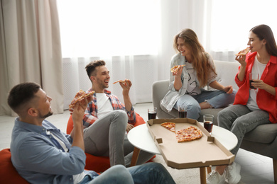 Photo of Group of friends eating tasty pizza at home