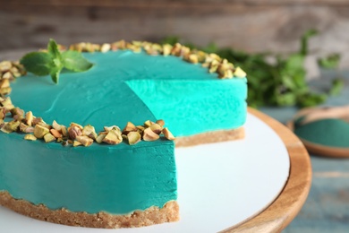 Tasty spirulina cheesecake on dessert stand, closeup view