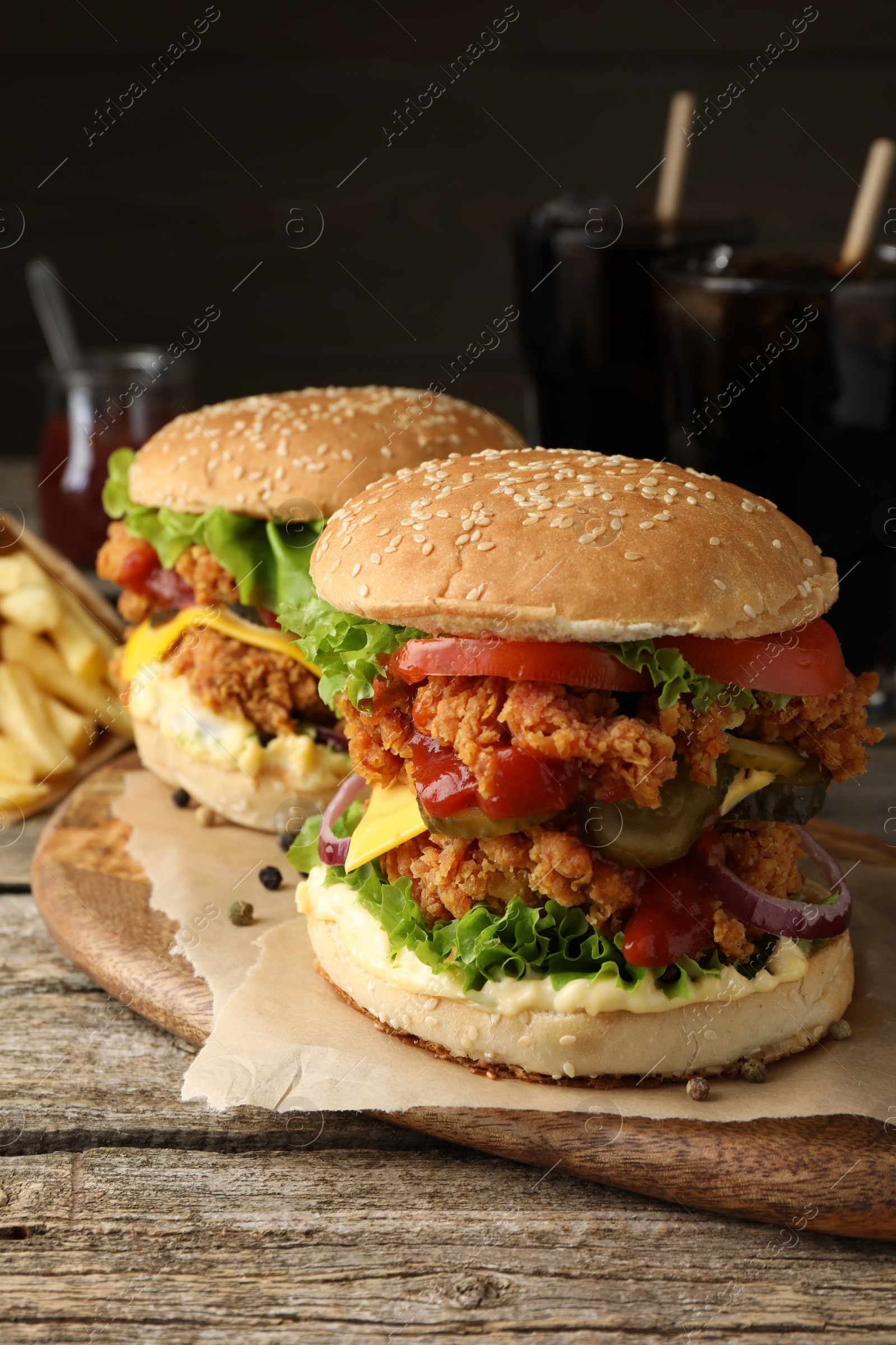 Photo of Delicious burgers with crispy chicken patty on wooden table