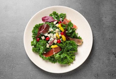 Photo of Tasty fresh kale salad on grey table, top view