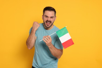 Photo of Emotional man with flag of Italy on yellow background