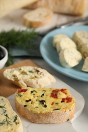 Photo of Different types of tasty butter and bread on table, closeup