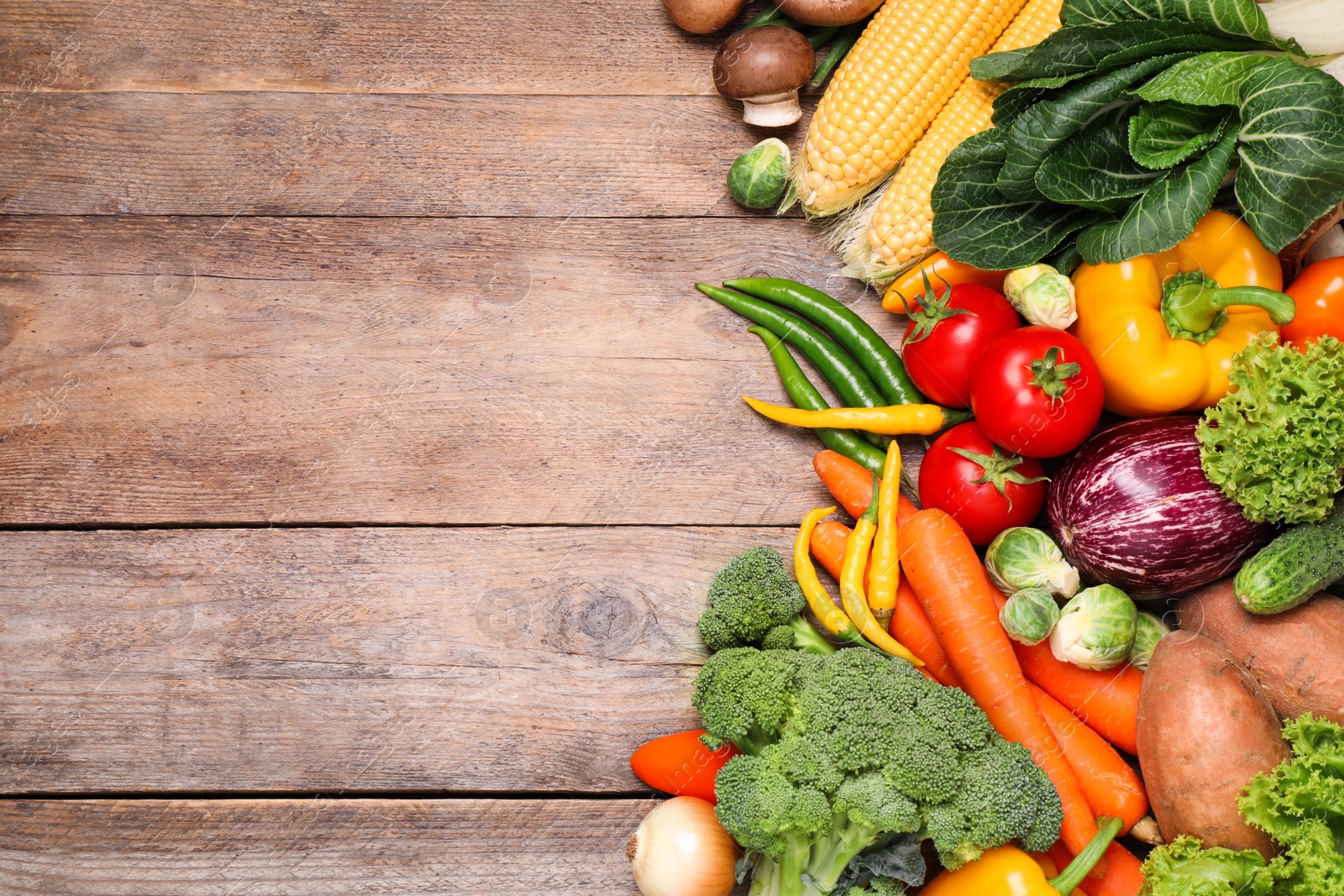 Photo of Different fresh vegetables on wooden table, flat lay. Space for text