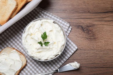 Photo of Toasted bread and delicious cream cheese with parsley on wooden table, flat lay. Space for text