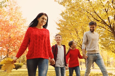 Photo of Happy family with children walking in autumn park