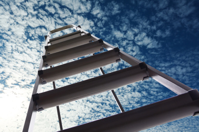 Image of Metal stepladder against blue sky with clouds, low angle view