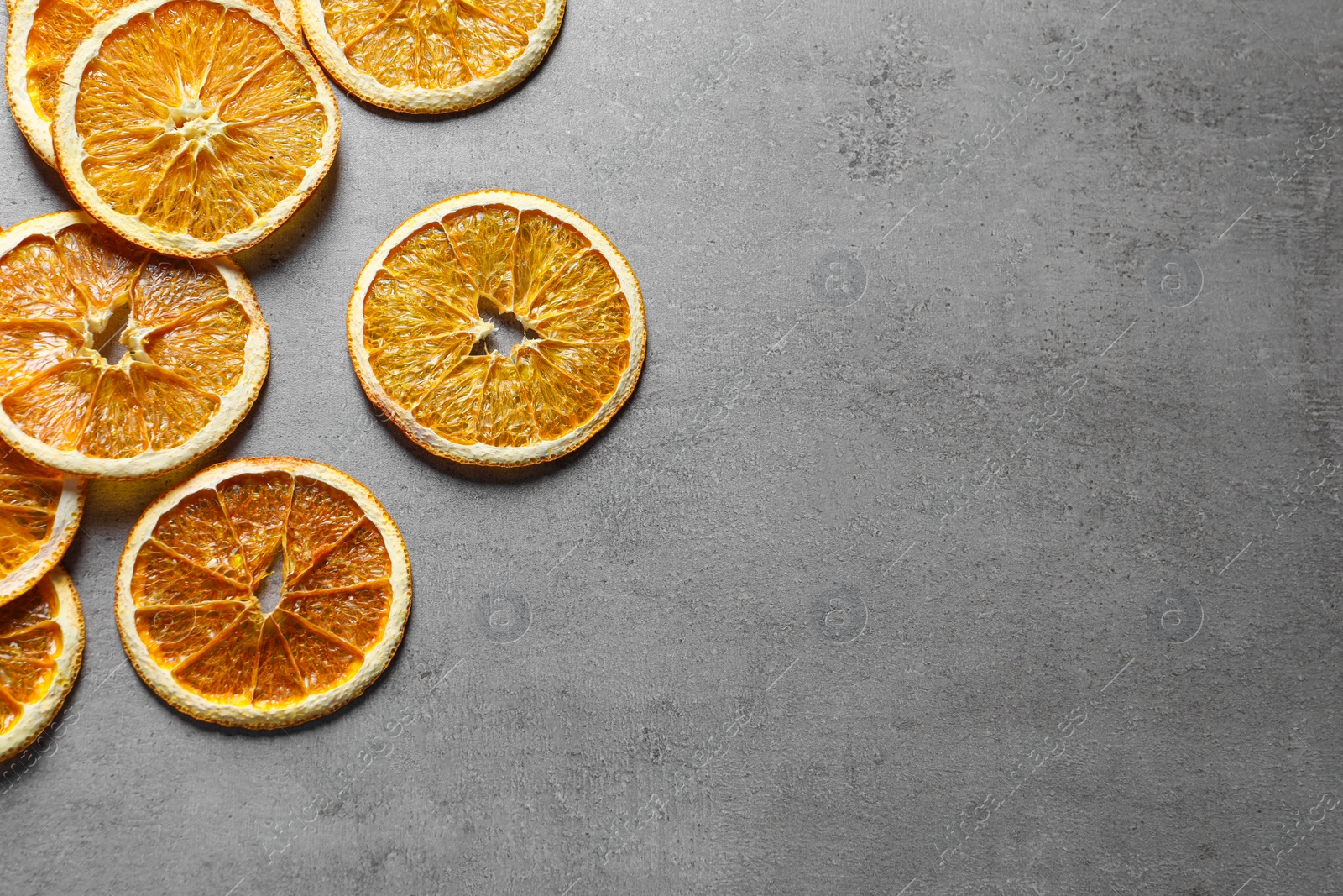Photo of Dry orange slices on light grey table, flat lay. Space for text