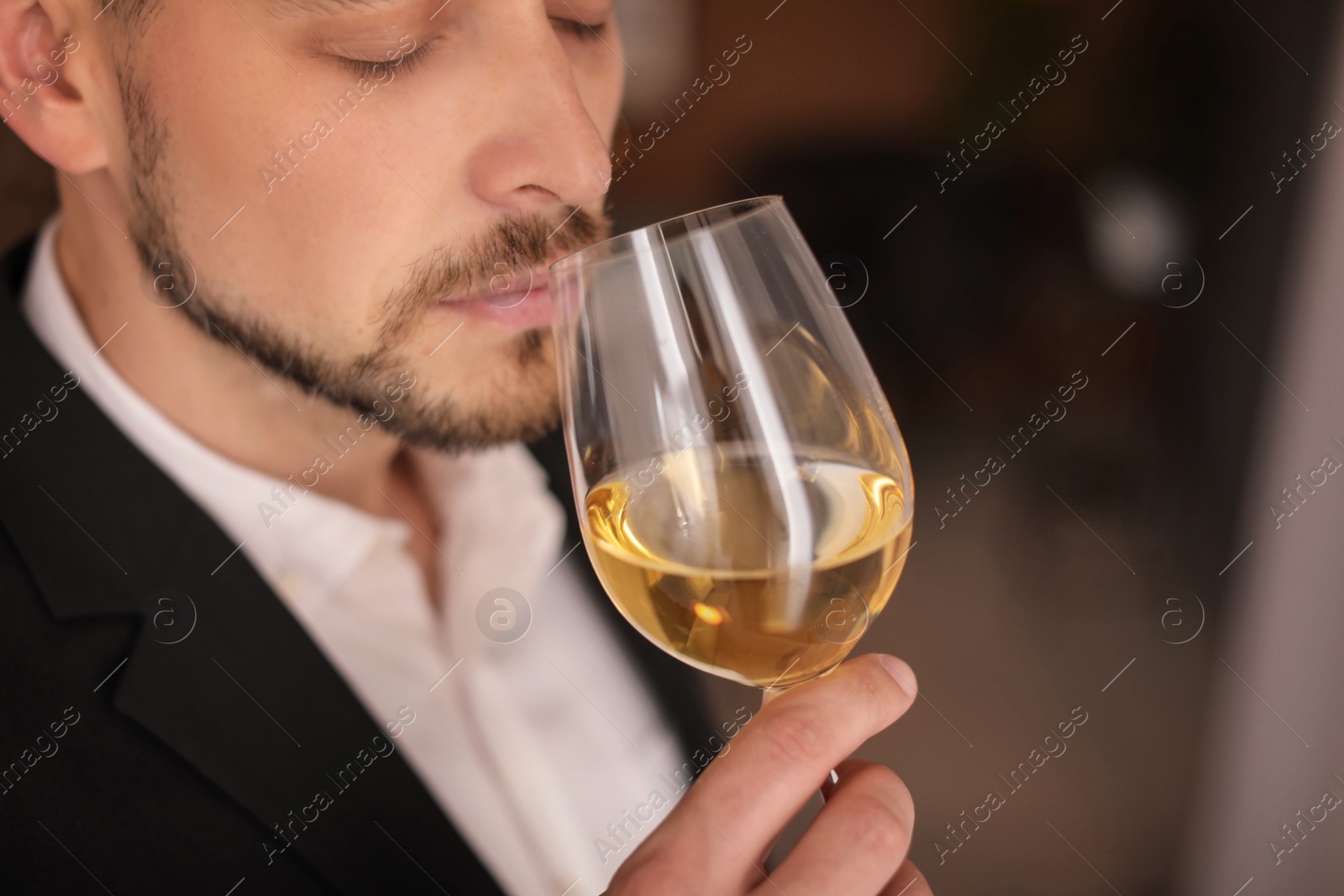 Photo of Young man with glass of wine indoors