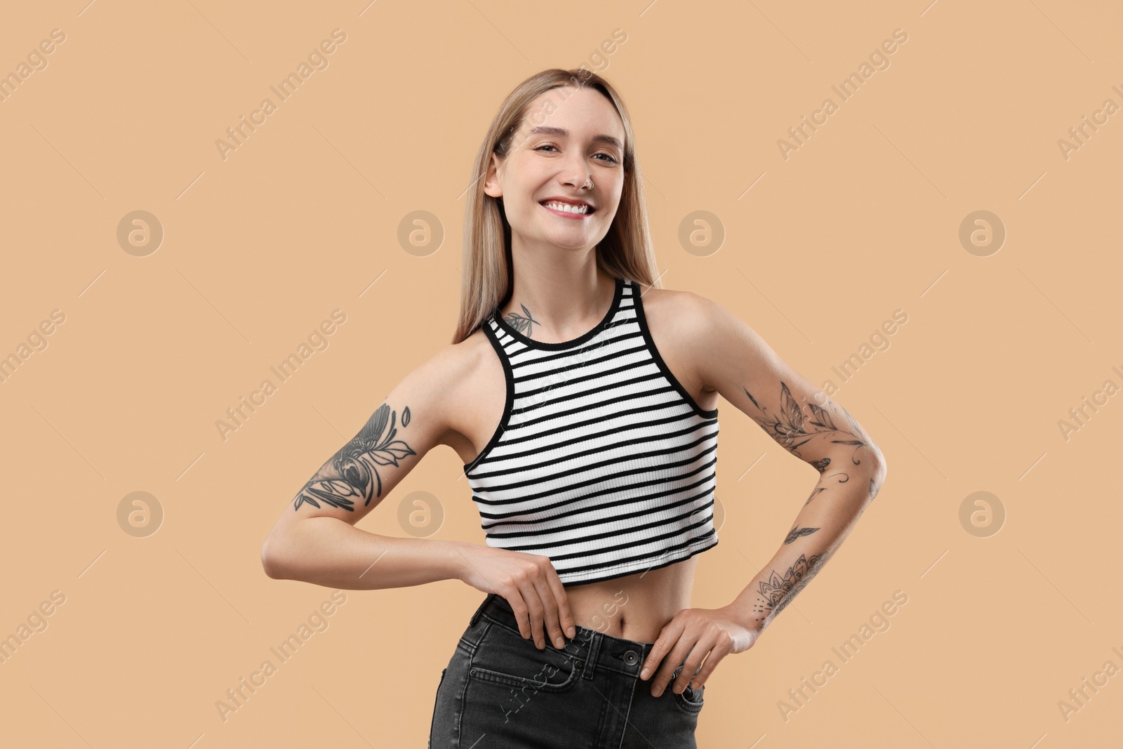 Photo of Portrait of beautiful tattooed woman on beige background