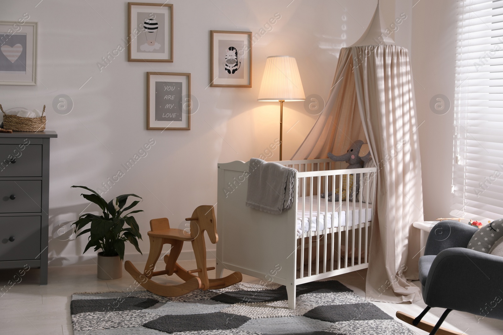 Photo of Stylish baby room interior with comfortable crib