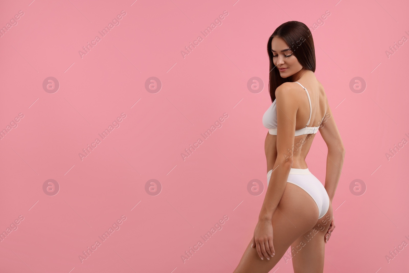 Photo of Young woman in stylish white bikini on pink background. Space for text