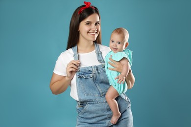 Beautiful mother with her cute baby on blue background