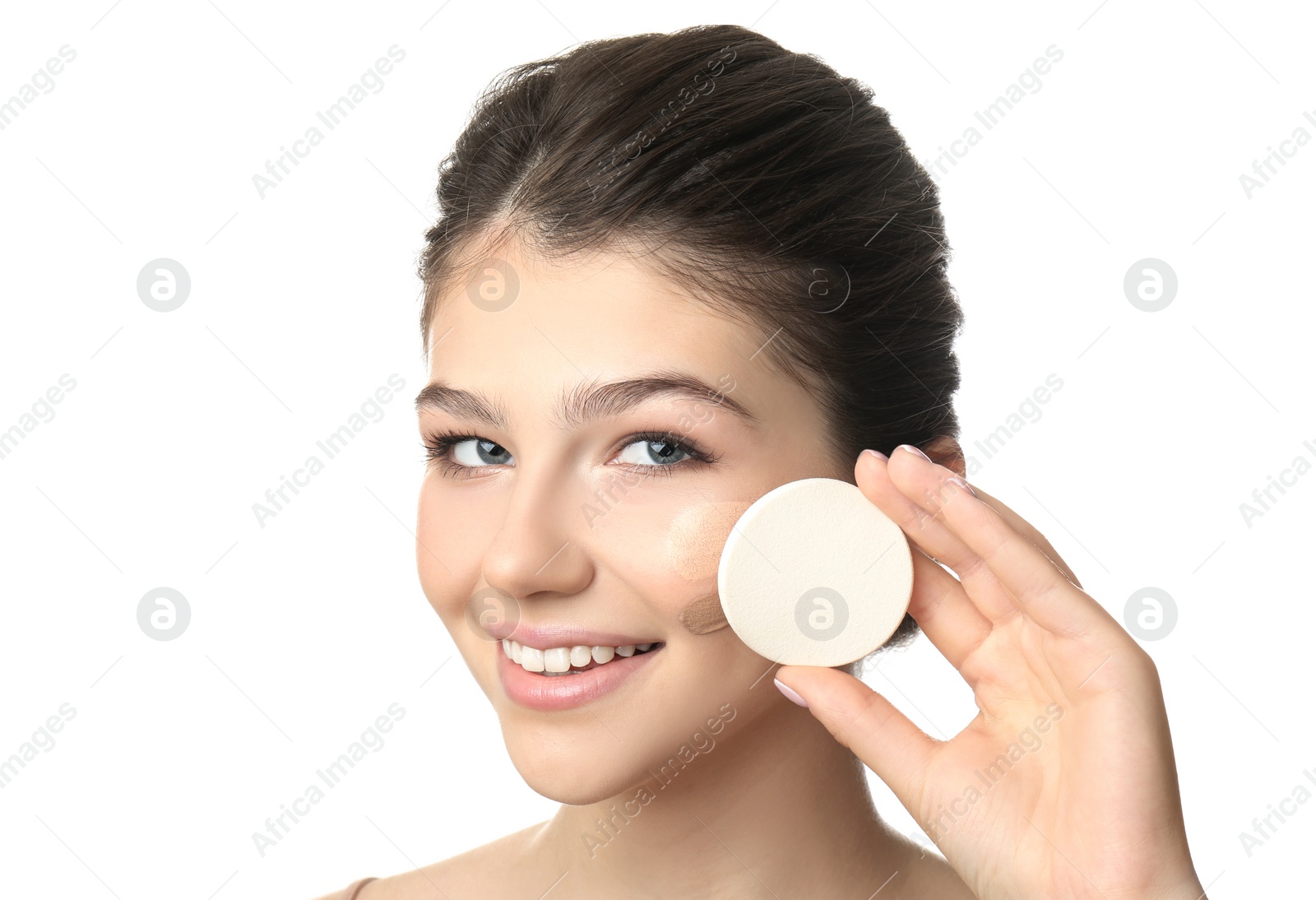 Photo of Beautiful girl with sponge on white background. Using concealer and foundation for face contouring