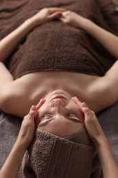 Spa therapy. Beautiful young woman lying on table during massage in salon