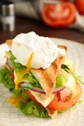 Photo of Tasty sandwich with poached egg on plate, closeup