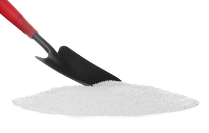 Pile of granular mineral fertilizer and scoop on white background