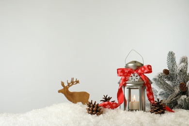 Photo of Beautiful composition with vintage Christmas lantern and festive decorations on snow against white background. Space for text