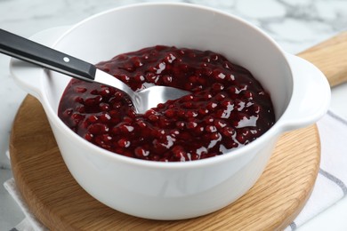Photo of Fresh cranberry sauce in bowl served on table, closeup
