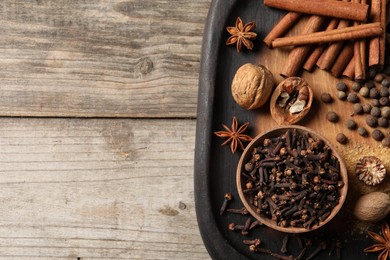 Photo of Different spices and nuts on wooden table, top view. Space for text