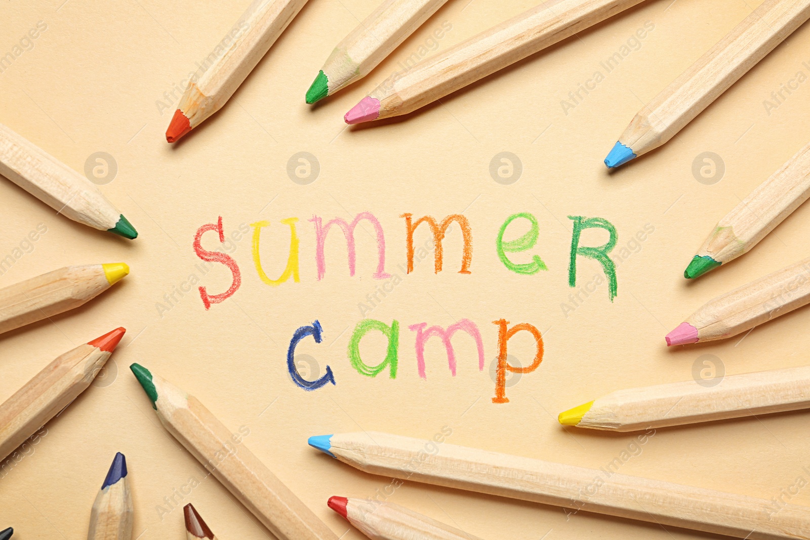 Photo of Text SUMMER CAMP and pencils on color background, flat lay