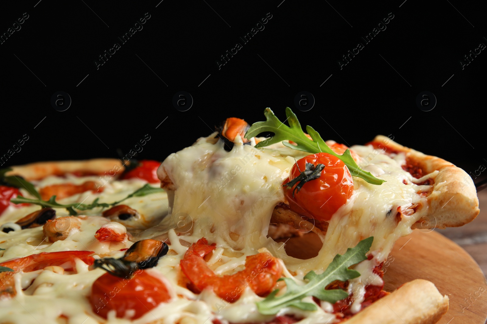 Photo of Delicious seafood pizza on wooden board, closeup