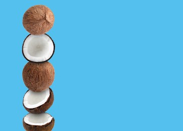 Image of Stack of fresh coconuts on light blue background. Space for text