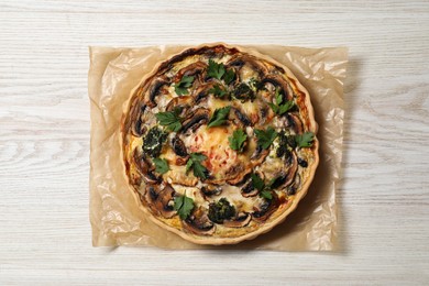 Delicious quiche with mushrooms and parsley on white wooden table, top view