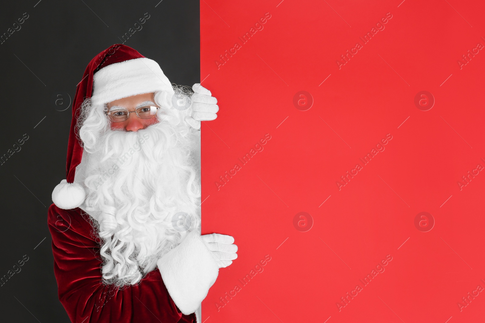 Photo of Santa Claus holding empty banner on black background