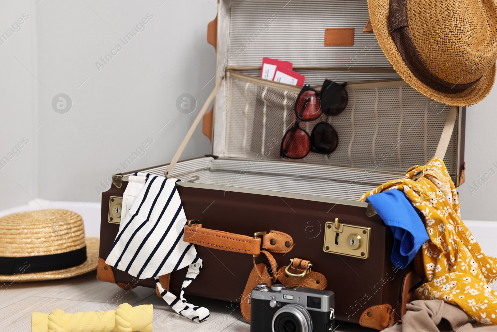 Photo of Clothes, camera and suitcase indoors. Prepare for travel