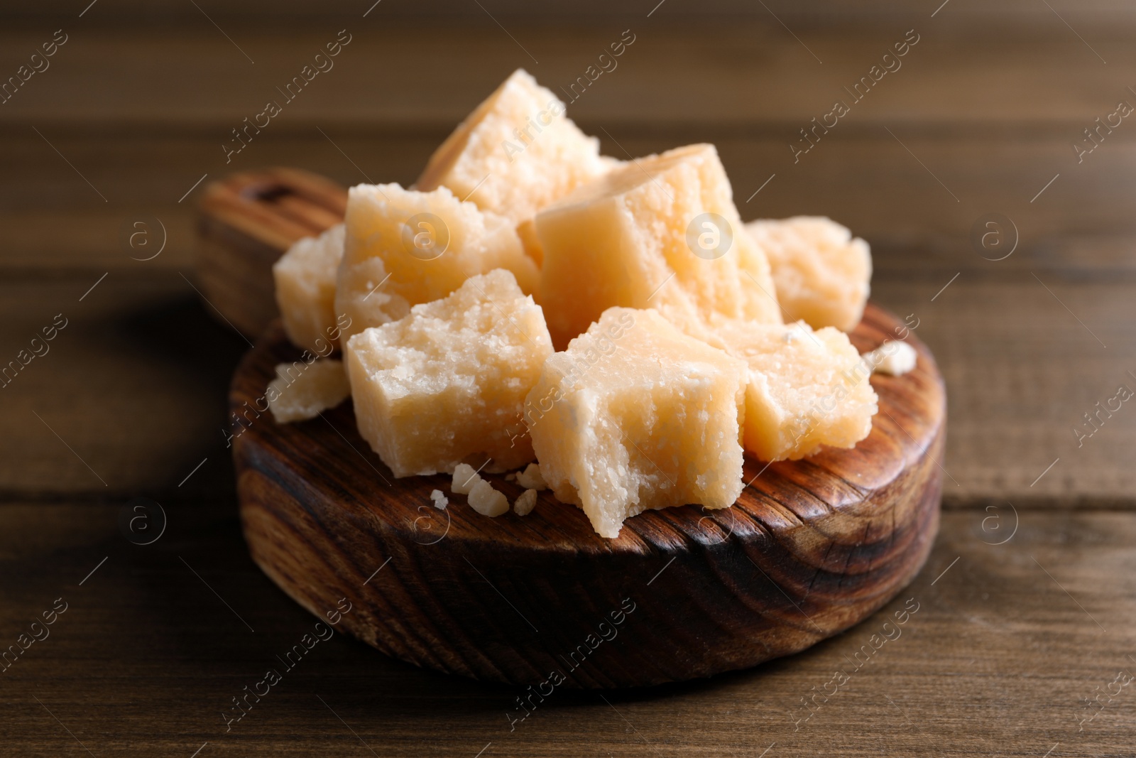 Photo of Pieces of delicious parmesan cheese on wooden table, closeup