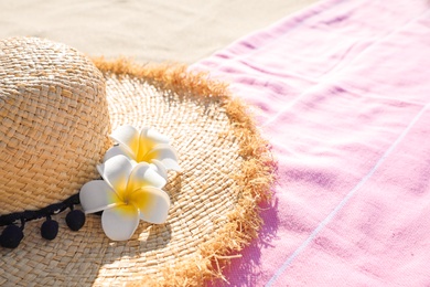 Straw hat and pink towel outdoors. Beach accessories